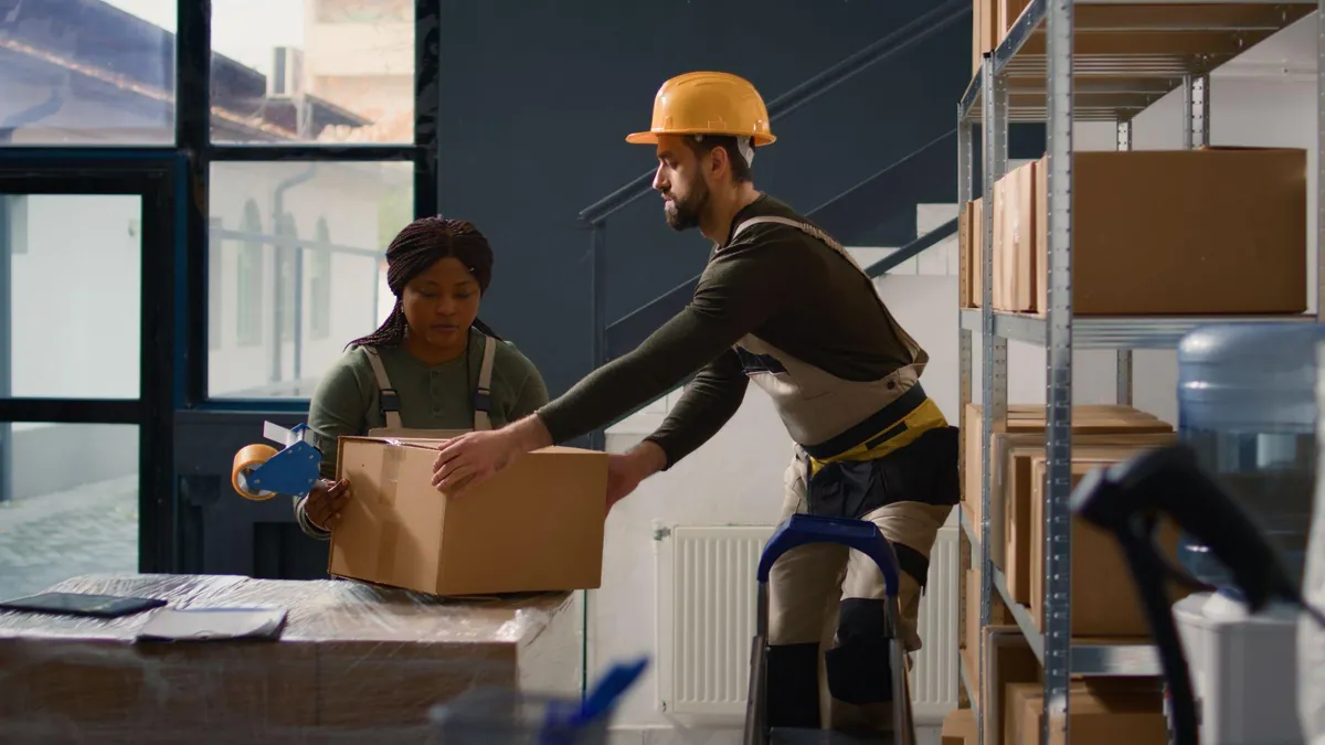 Professional movers packing and taping household boxes for export shipping